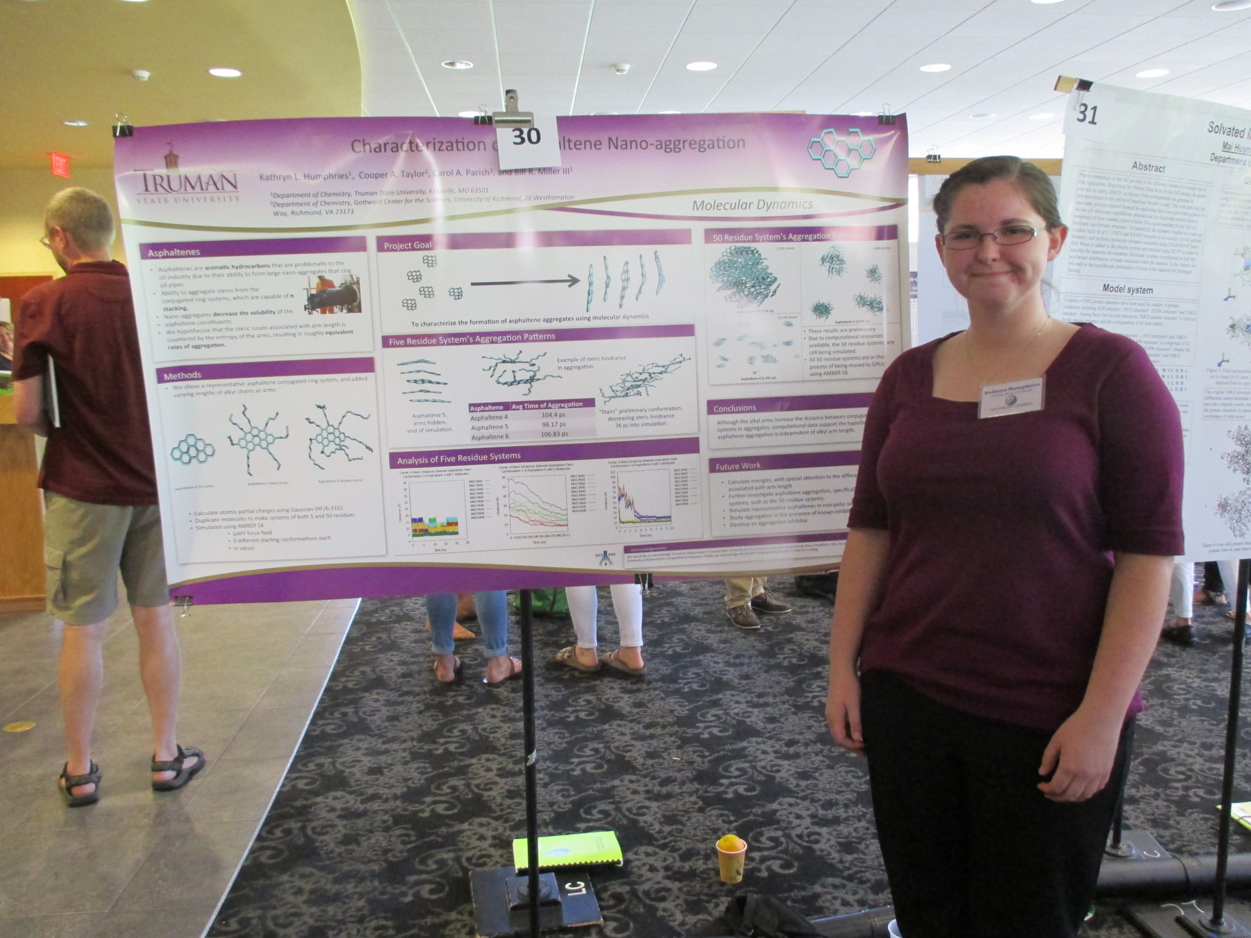 Katy in front of her research poster on asphaltene aggregation