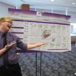 Andy showing off his research poster about DNA polymerase